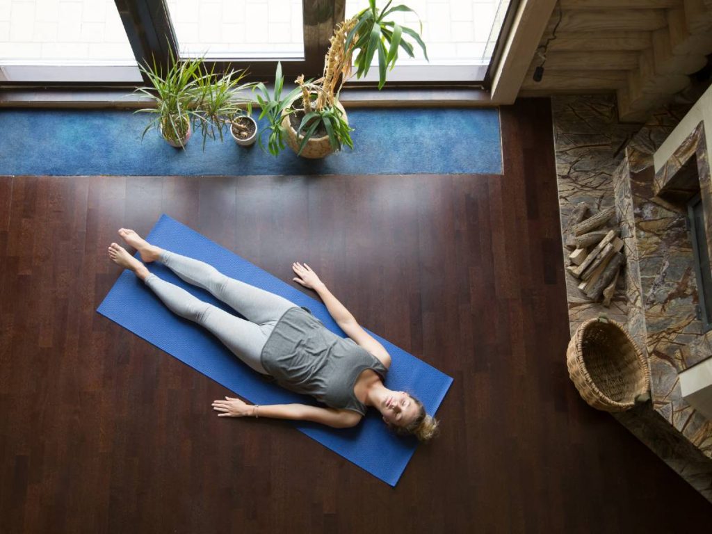 Woman lying on the floor in yoga corpse pose
